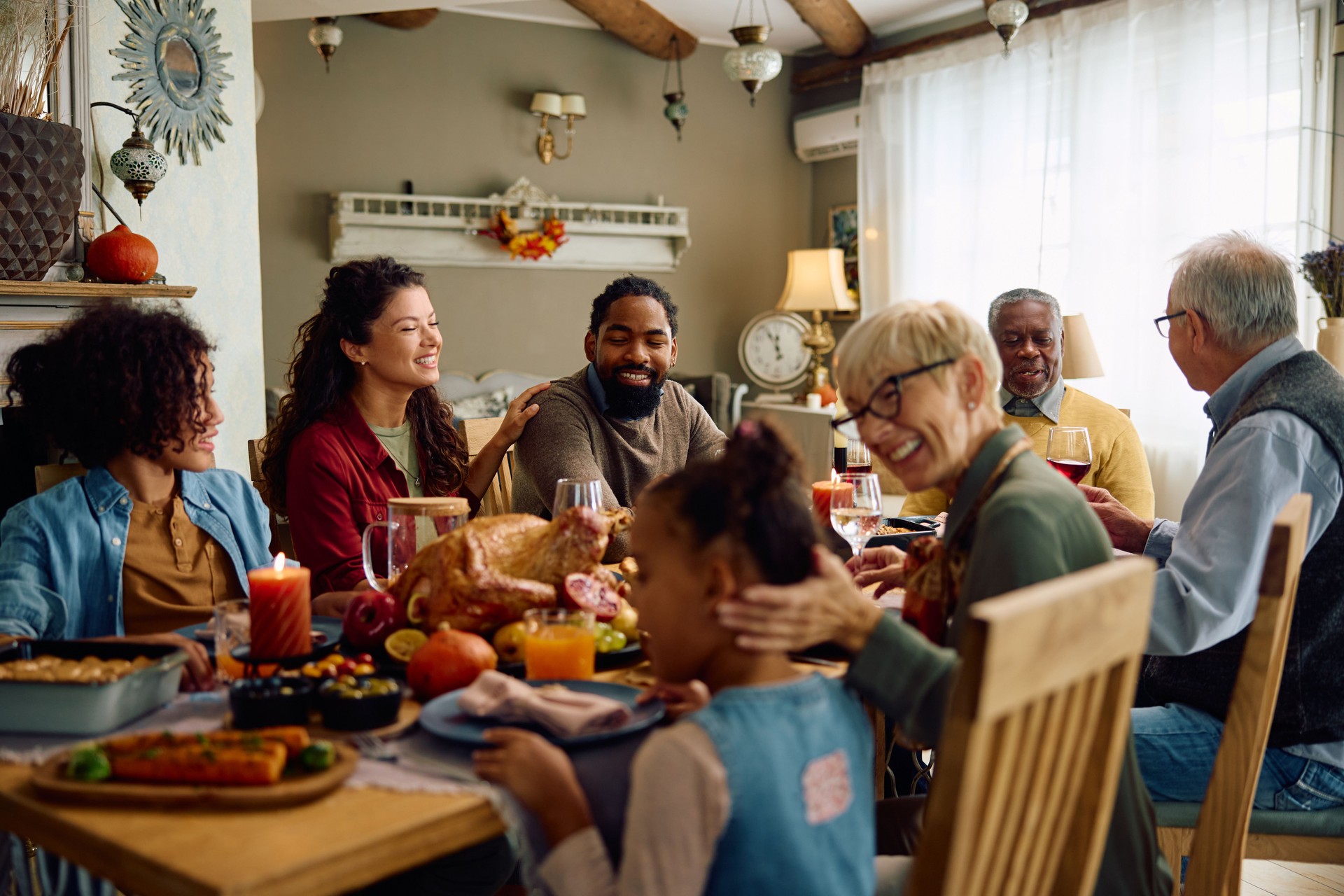 Heureuse famille élargie multiraciale célébrant Thanksgiving à la table à manger.